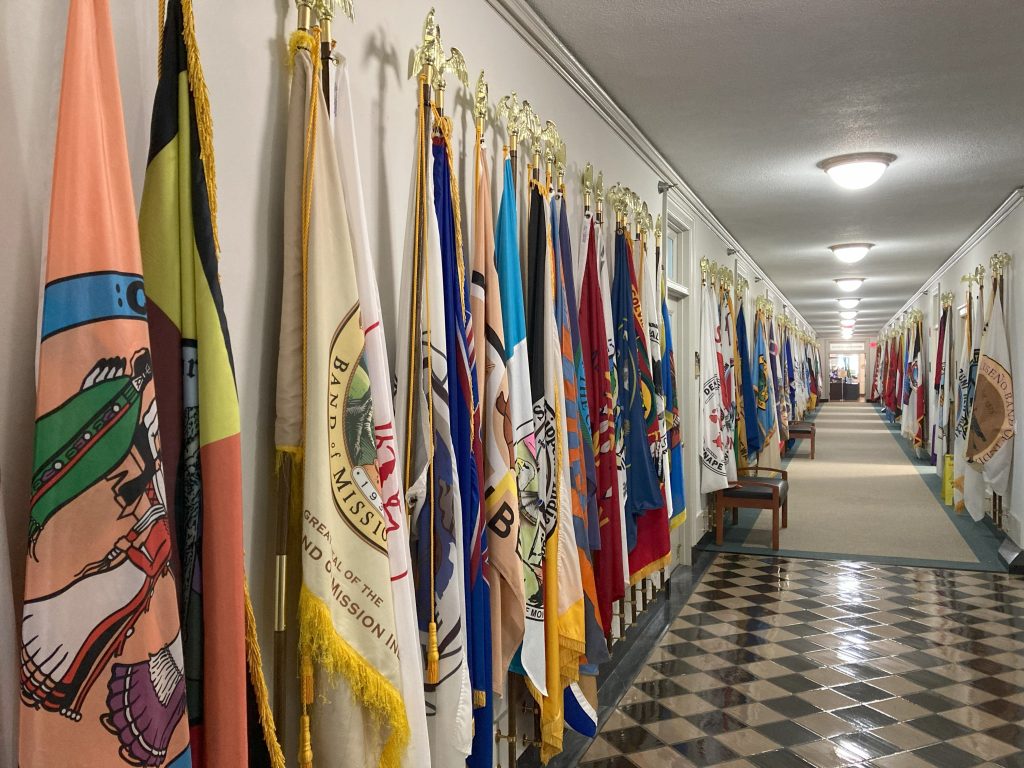 A hallway filled with flags from Tribal nations.