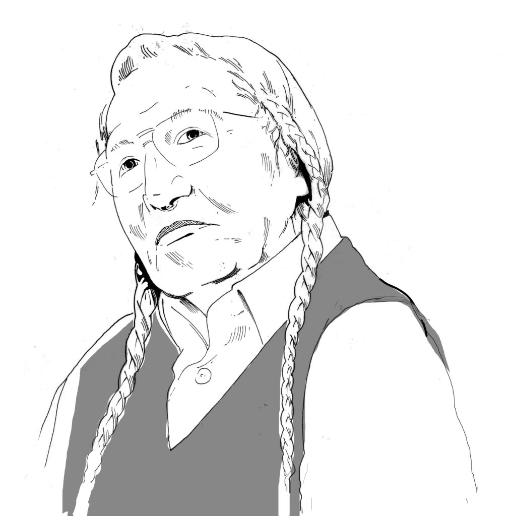 An elder man with glasses and two long braids.